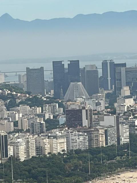 Distant telephoto of Rio's downtown skyscrapers and modern cathedral on a hazy day.