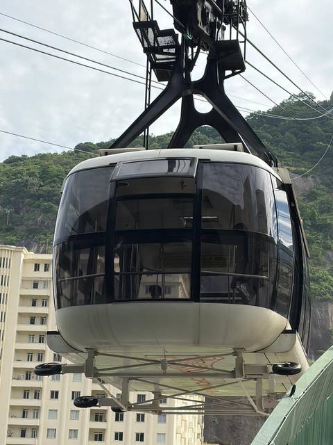 Close-up of Sugarloaf cable car cabin with lush hillside background.