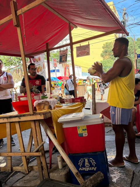 Street vendor demonstrating how to serve fresh coconut juice at an outdoor fair.