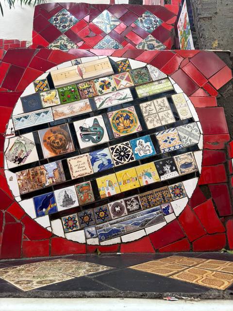 Circular mosaic of colorful hand-painted tiles displayed on the Selarón Steps landing.