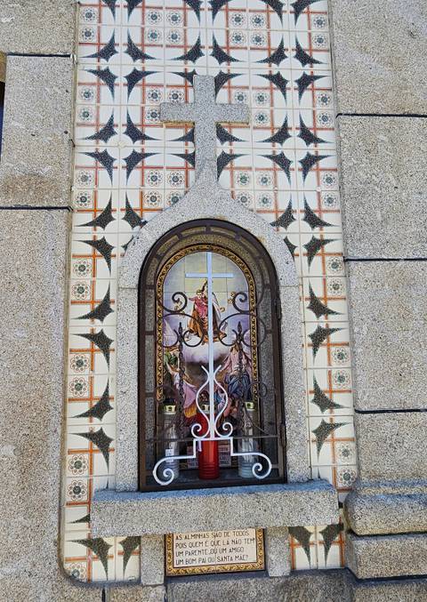 Decorative azulejo tile panel with religious imagery framed by patterned ceramic squares.