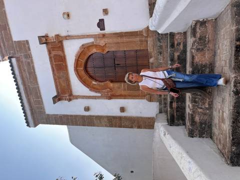 Woman descending stone steps beside ornate arched doorway of historic building