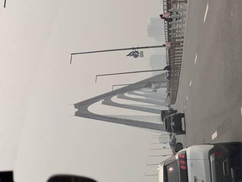 Vehicles crossing the modern cable-stayed Nhat Tan Bridge under hazy skies.
