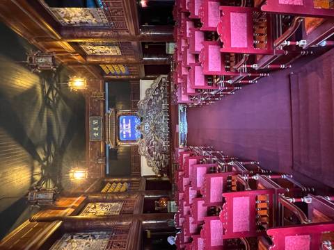 Ornate royal theatre hall lined with red velvet chairs inside Hue Citadel.