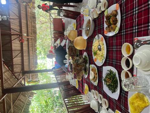 Traditional Vietnamese meal spread on a red-checked tablecloth in an open-air restaurant.