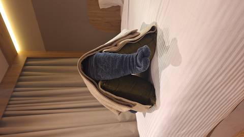 Playful towel elephant sculpture arranged on a neatly made hotel bed.