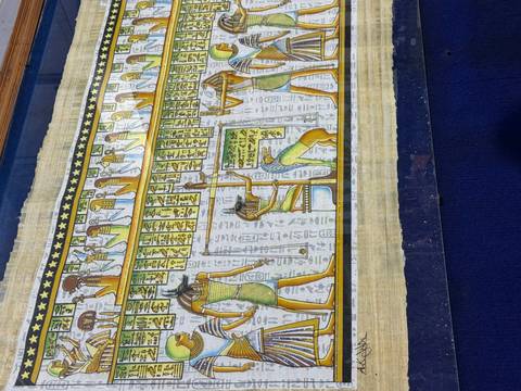 Colourful papyrus artwork depicting ancient Egyptian gods and hieroglyphs on a royal blue background.