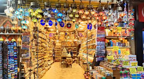 Vibrant Turkish bazaar stall filled with colourful lanterns, spices and souvenirs with a vendor inside.