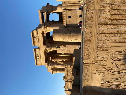 Well-preserved Egyptian temple columns and carved hieroglyphics bathed in warm afternoon light.