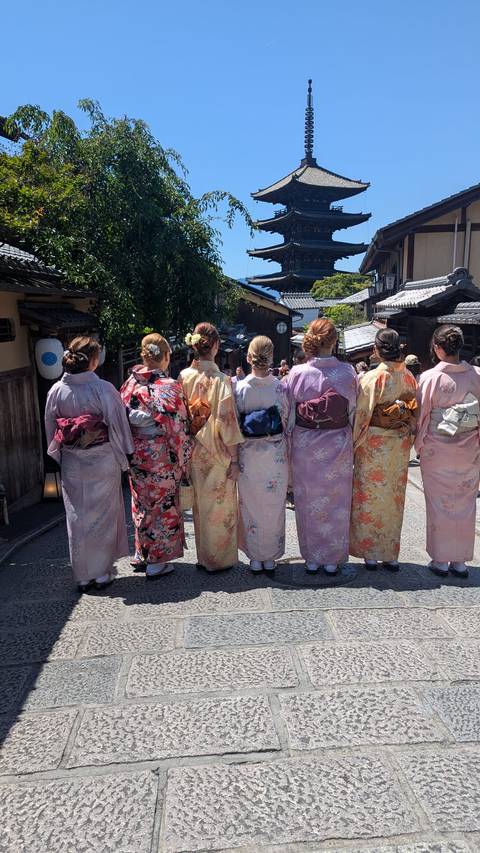 Women dressed in colorful kimonos seen from behind on a traditional Kyoto street