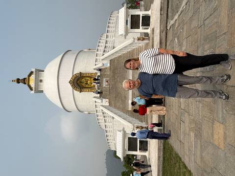 Visitors posing on the steps of the World Peace Pagoda overlooking Pokhara