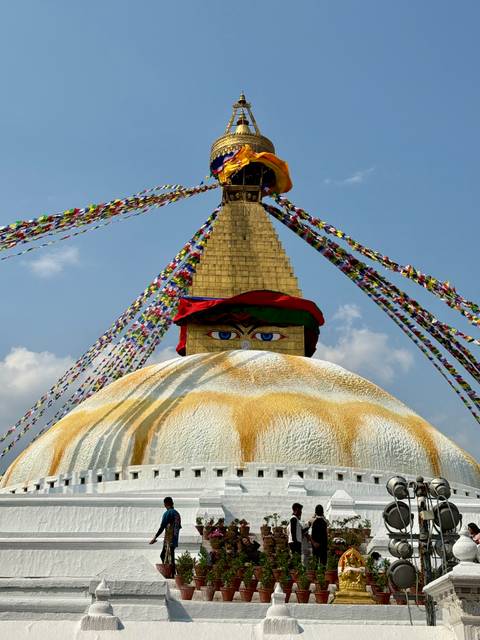 Iconic eyes of Buddha on the golden stupa of Swayambhunath adorned with colorful prayer flags
