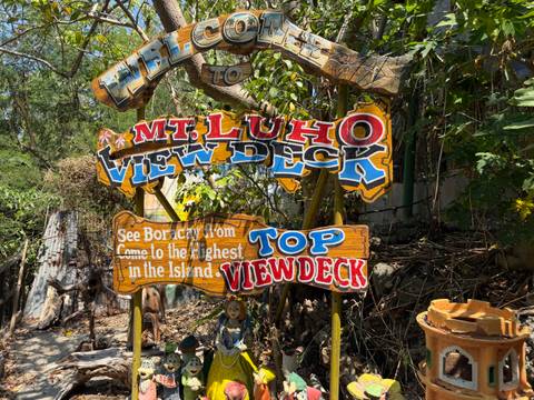 Colorful wooden signs pointing to Mt. Luho top view deck on Boracay