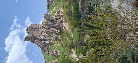 Jagged volcanic tuff castle riddled with cave dwellings rising above Cappadocia landscape