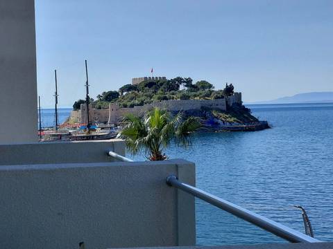 Island fort and sailing boats seen across blue Aegean waters from Kusadasi