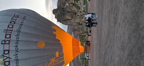 Hot-air balloon being inflated at dawn against rocky spires of Cappadocia