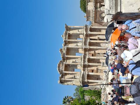 Large crowd entering the ancient Library of Celsus ruins at Ephesus under clear blue sky