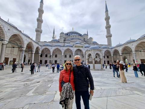 Couple posing in the expansive marble courtyard of the Blue Mosque in Istanbul