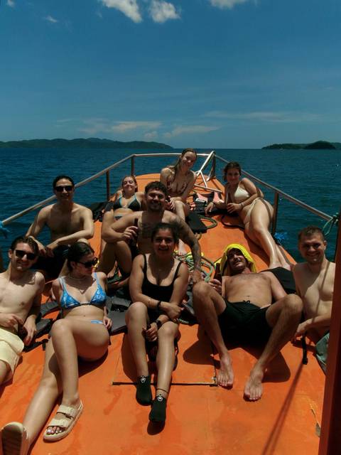 Young travellers relaxing on deck of small boat in open sea on a sunny day