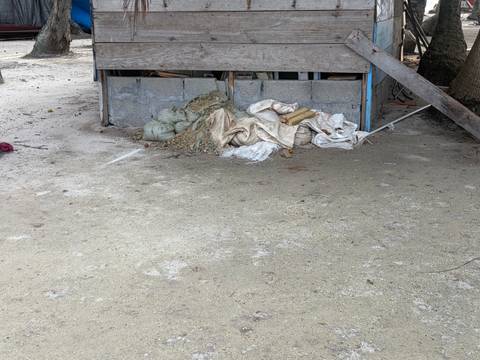 Construction debris and sand piled beneath a raised wooden structure