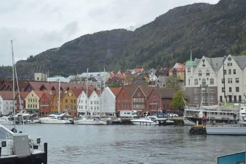 Colourful wooden warehouses of Bryggen along Bergen’s harbour with boats moored in front