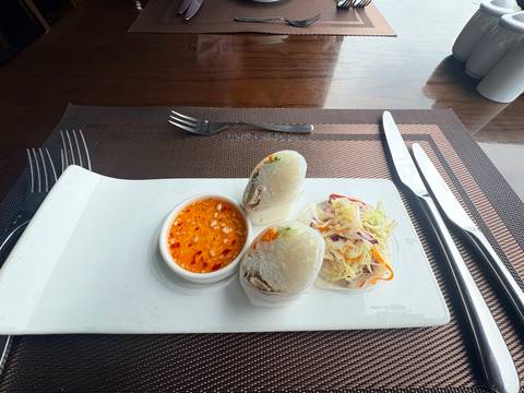 Fresh Vietnamese spring rolls served with sweet chilli dipping sauce on a rectangular plate.