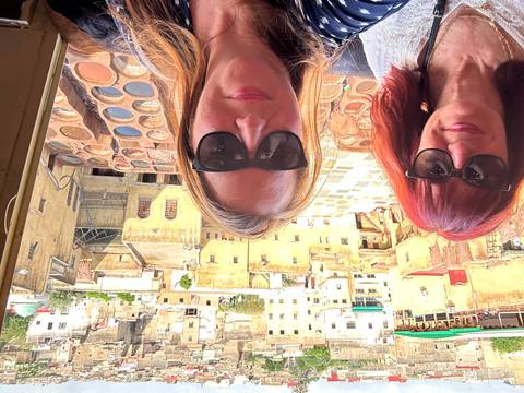 Selfie of two women overlooking the colorful leather vats of Fes tannery.