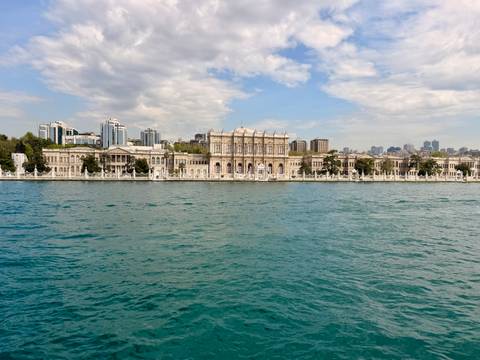 Grand Dolmabahçe Palace façade viewed across the shimmering Bosphorus waters in Istanbul.