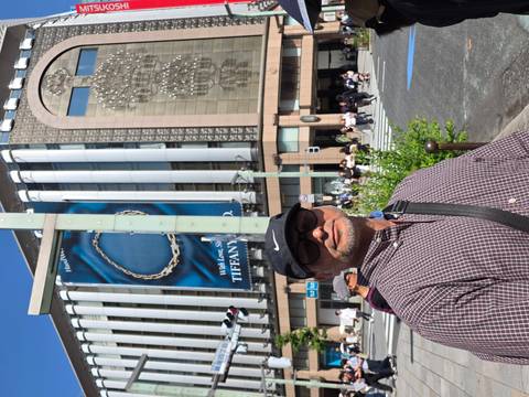 Man on a Tokyo street corner in Ginza with Tiffany & Co. building backdrop.