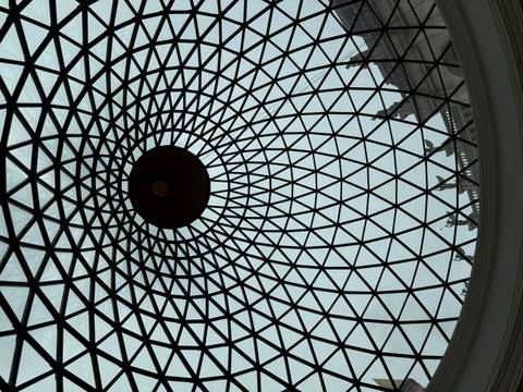Interior view of a patterned glass dome ceiling with a geometric lattice and central oculus.