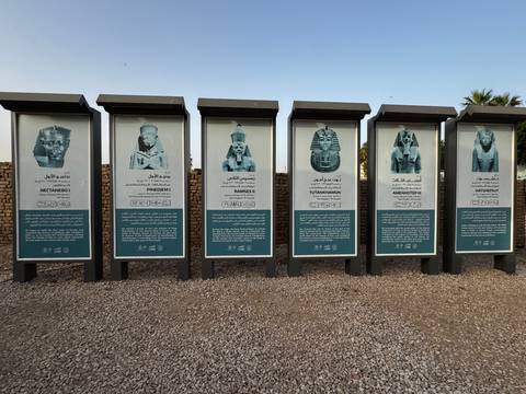 Row of outdoor panels displaying images and descriptions of ancient Egyptian pharaohs in Luxor.