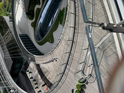 Modern spiral ramp and glass roof courtyard of a contemporary building viewed from above.