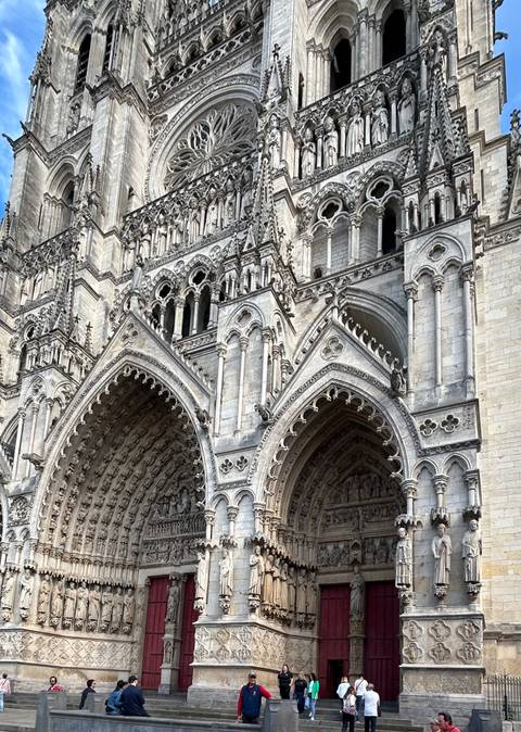 Close-up of ornate stone arches and carvings on a grand Gothic cathedral entrance.