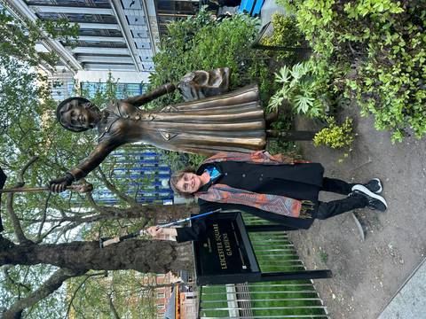 A woman poses with the bronze Mary Poppins statue in Leicester Square Gardens, London.