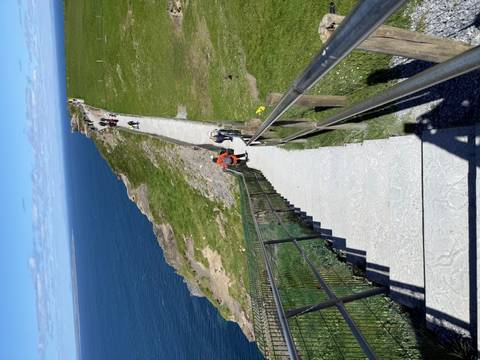 A long concrete stairway leads walkers up a grassy cliff path beside the Atlantic.