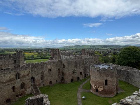 Aerial-style view of Ludlow Castle ruins overlooking green English countryside