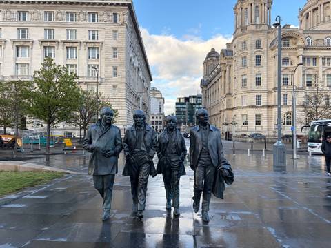 Bronze statues of The Beatles on Liverpool’s waterfront promenade after rain