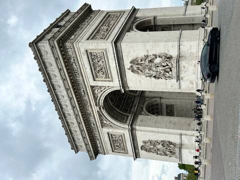 Close perspective of the Arc de Triomphe showing ornate reliefs and archway.
