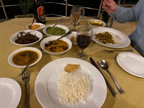 Traditional Sri Lankan dinner spread with curries, rice and papadam on a table.