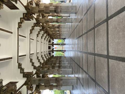 Symmetrical stone colonnade of a memorial hall with geometric ceiling and tiled floor