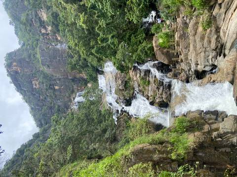 Multi-tiered waterfall cascading down jungle-clad cliffs