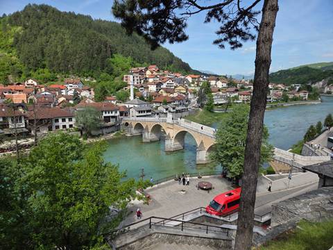 Historic multi-arch stone bridge over turquoise river seen from elevated viewpoint