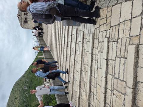 Visitors ascending steep stone steps on the side of Mostar’s historic bridge