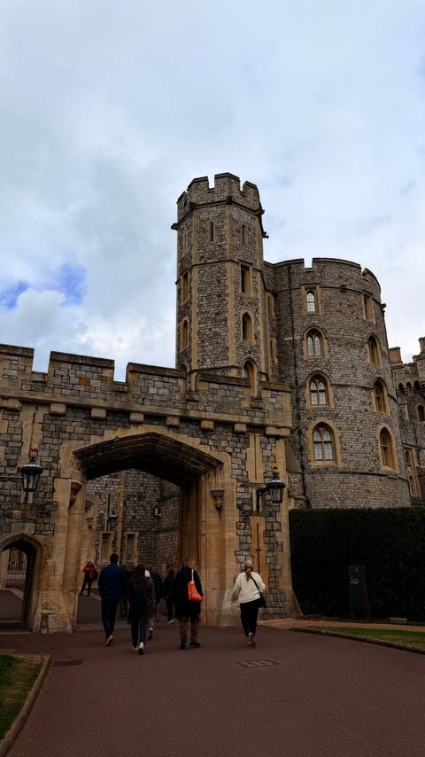 Stone gateway and towers at Windsor Castle display Gothic windows and weathered masonry.