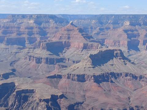 Closer telephoto view of the layered mesas and ridges inside the Grand Canyon under clear skies.