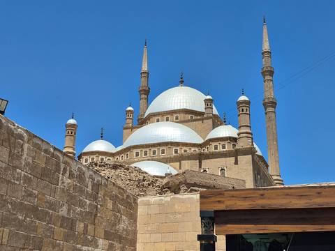 The domes and minarets of the Mosque of Muhammad Ali gleaming under a bright blue sky.