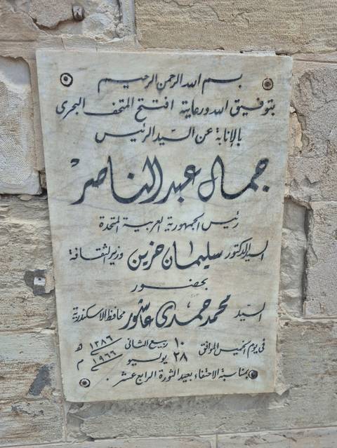 Close-up of Arabic inscription plaque carved on aged marble.