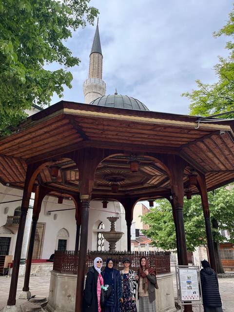 Timber-roofed octagonal fountain structure with carved beams in an old mosque courtyard