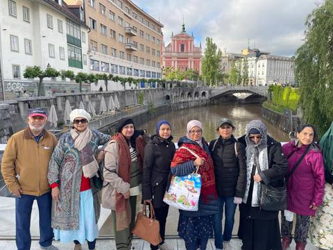 Group photo on Ljubljana’s Triple Bridge with the pink Franciscan Church and river behind