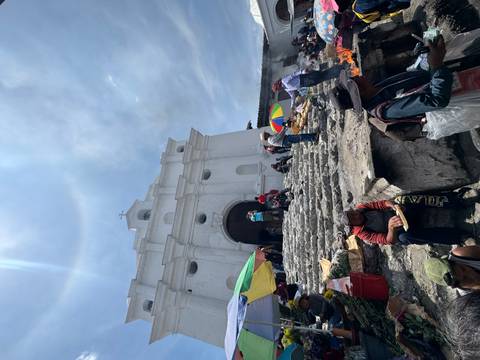 Locals and visitors gather on the stone steps of Chichicastenango’s white church amid incense smoke.